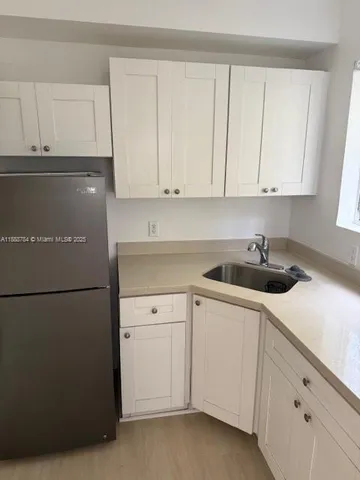 a kitchen with white cabinets and white appliances