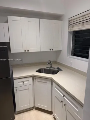 a kitchen with white cabinets and white appliances