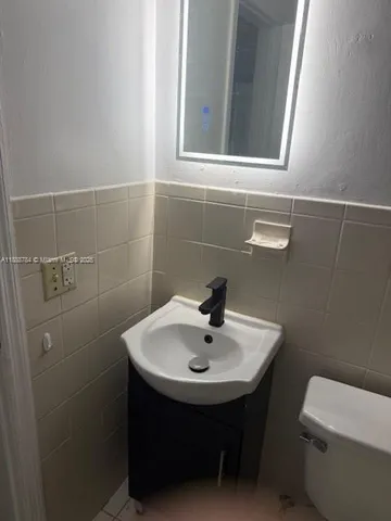 a bathroom with a sink a toilet and mirror