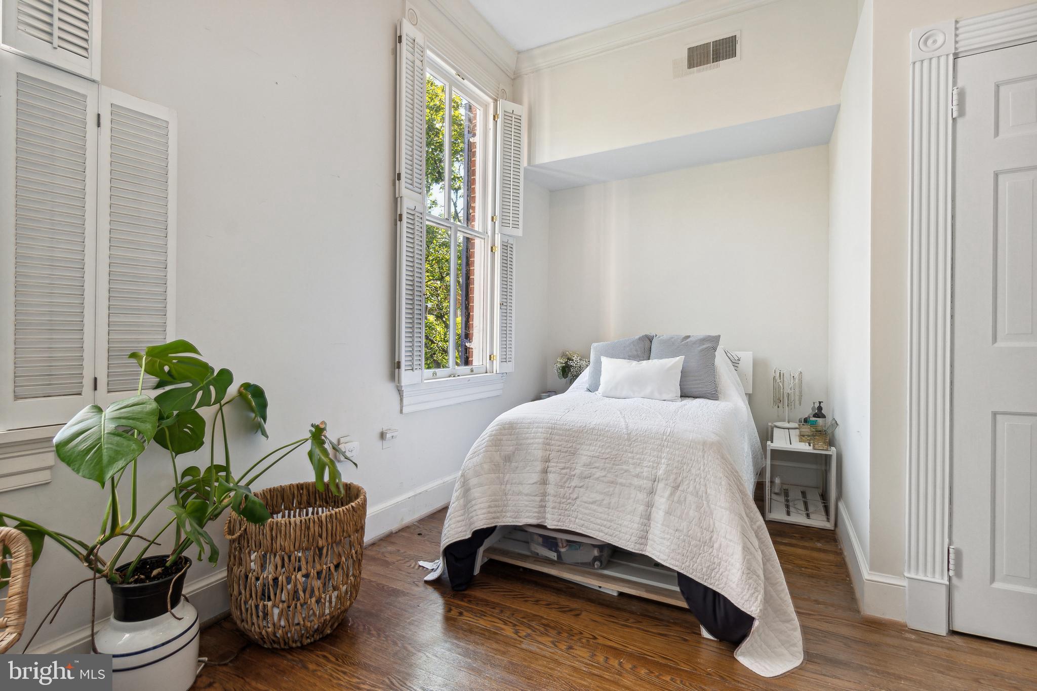 1244 34th Street Northwest Washington, DC 20007 - Photo 12 of 26 a bedroom with a bed potted plant and a window