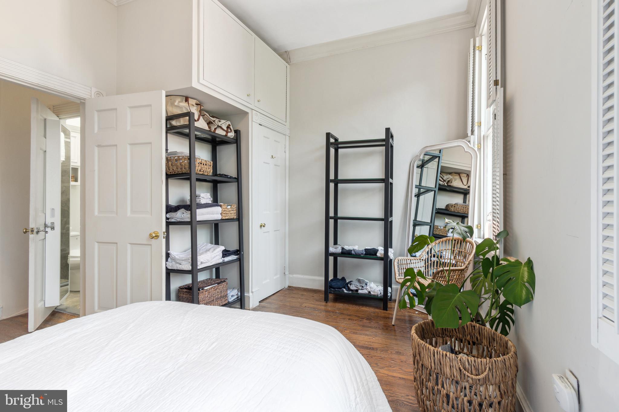 1244 34th Street Northwest Washington, DC 20007 - Photo 13 of 26 a bedroom with a bed a bookshelf and a potted plant