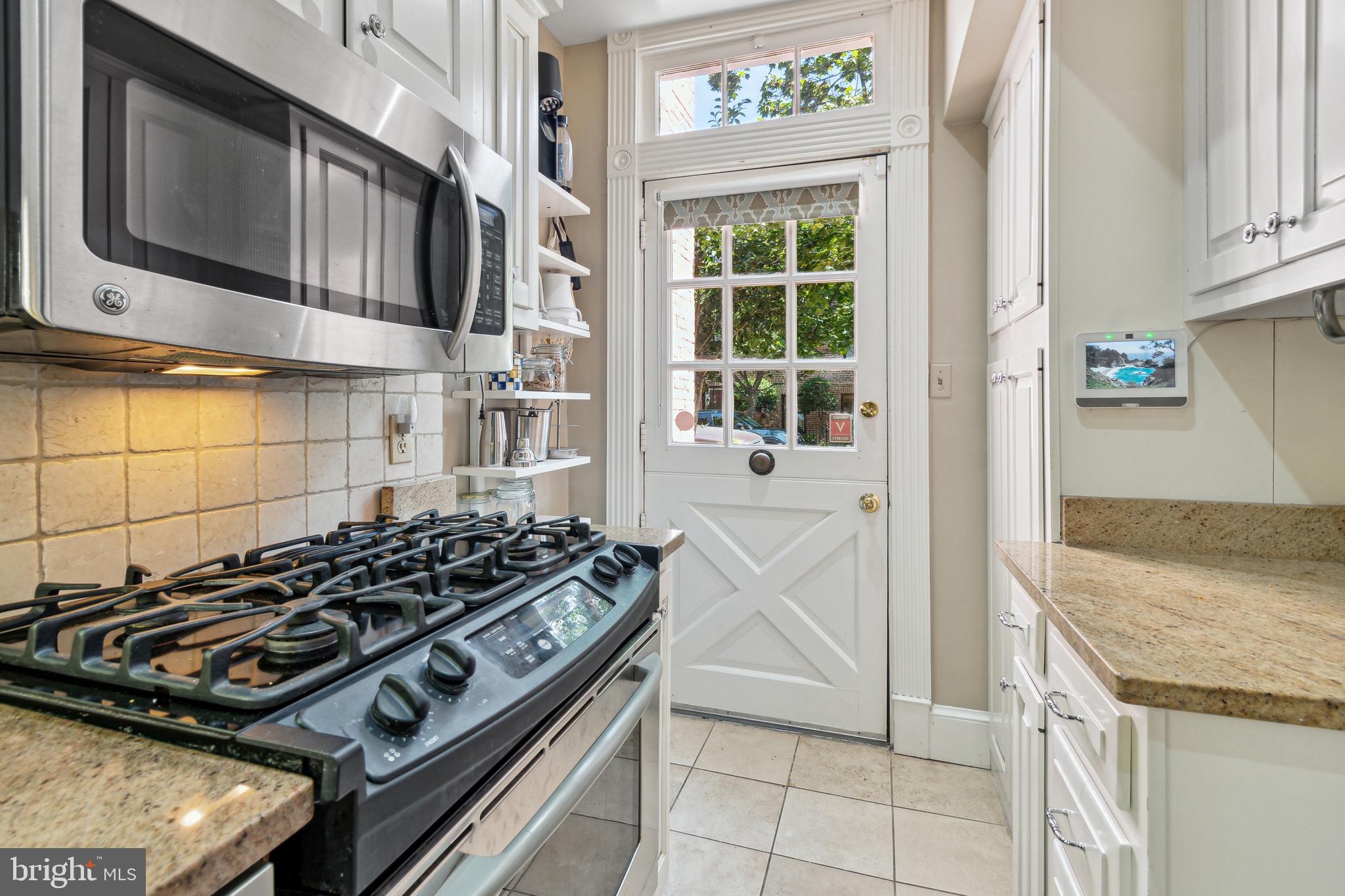 1244 34th Street Northwest Washington, DC 20007 - Photo 16 of 26 a kitchen with stainless steel appliances granite countertop a stove and a refrigerator