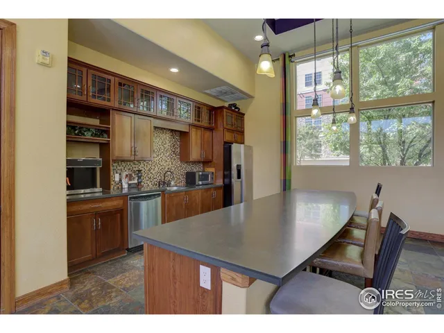 a kitchen with kitchen island a counter top space appliances and a window