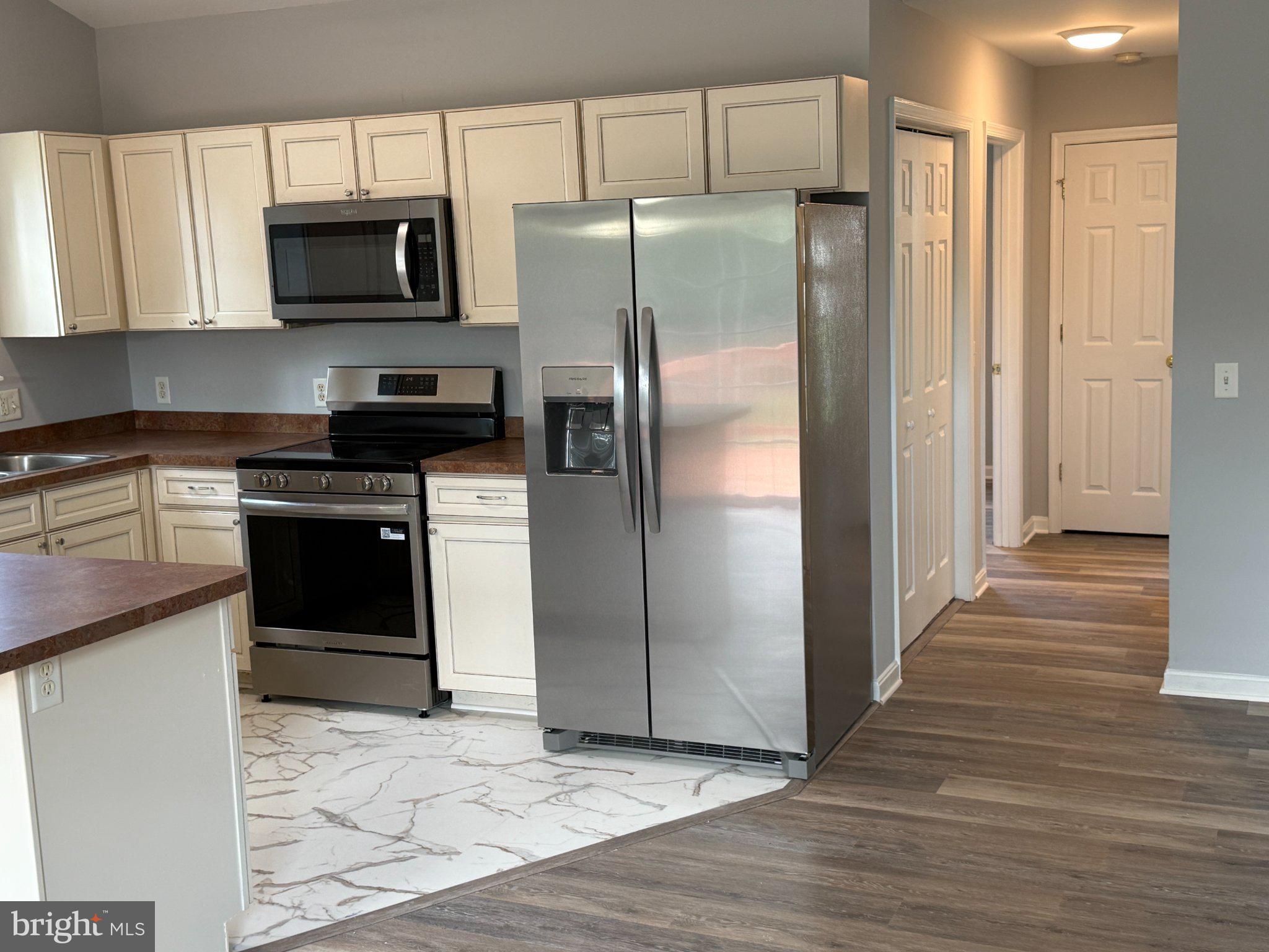 30952 Sandy Ridge Drive Lewes, DE 19958 - Photo 8 of 17 a kitchen with stainless steel appliances granite countertop a refrigerator and a stove top oven