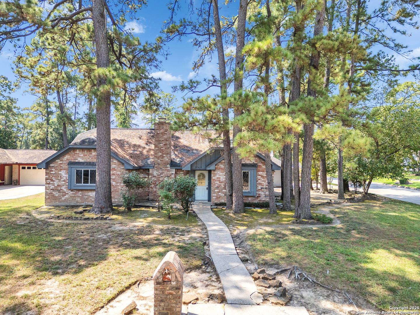 a front view of a house with a yard tree and outdoor seating
