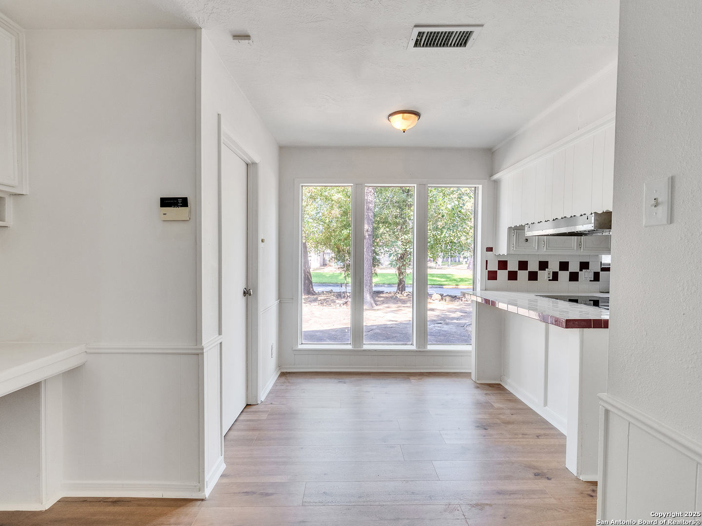 25423 Old Carriage Lane Spring, TX 77373 - Photo 14 of 36 a kitchen with granite countertop a stove top oven a sink and white cabinets with wooden floor