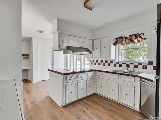a kitchen with stainless steel appliances granite countertop a sink and cabinets