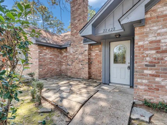 a view of a brick house with a large tree