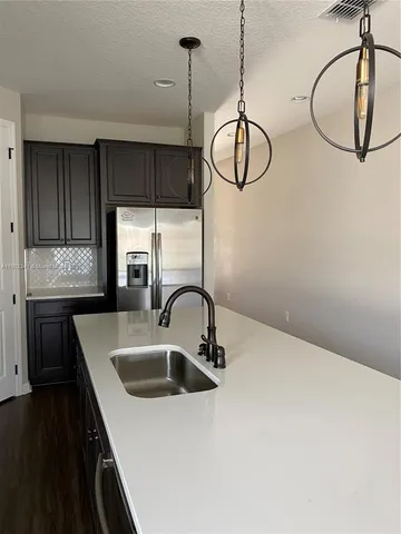 a kitchen with a sink a counter space cabinets and appliances