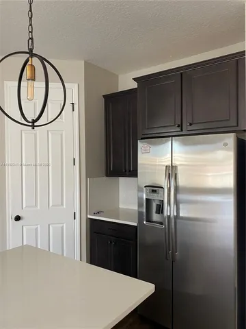 a kitchen with granite countertop a refrigerator and a sink