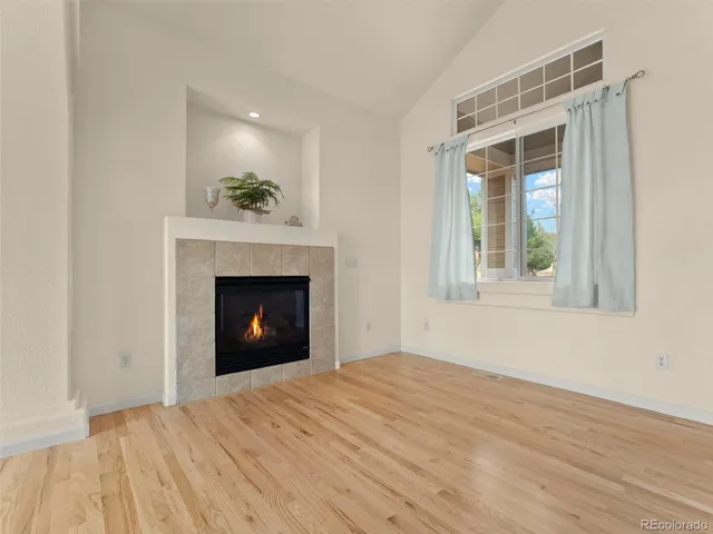 a view of an empty room with a window and fire place