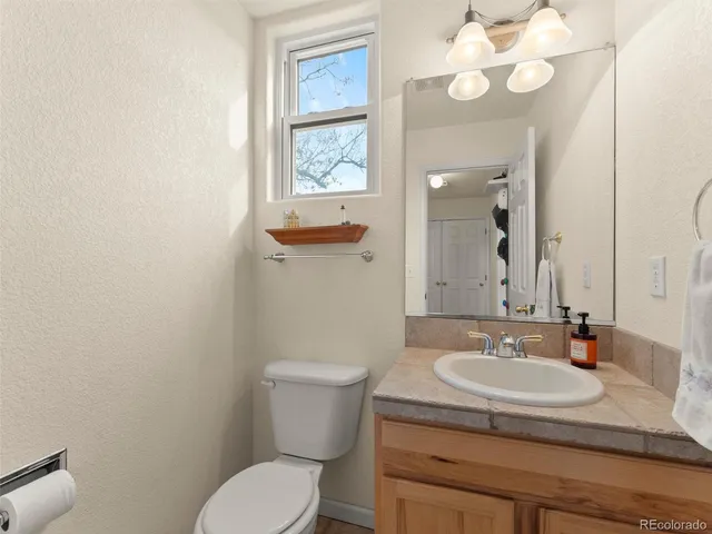 a bathroom with a sink a toilet and a mirror