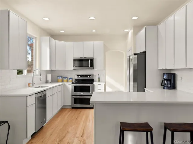 a kitchen with white cabinets and stainless steel appliances