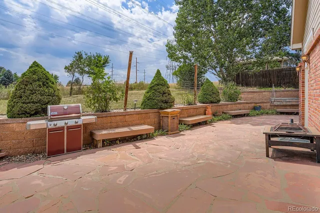 a backyard of a house with barbeque oven and outdoor seating