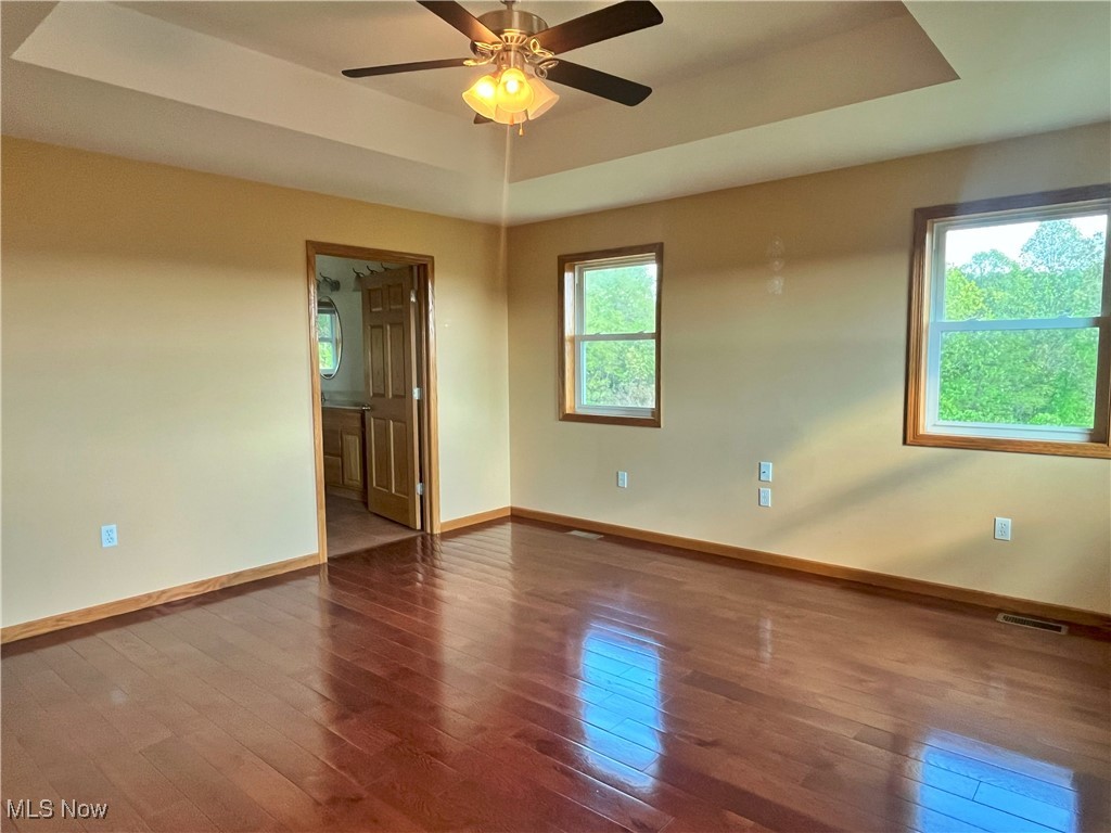17583 Davis Ridge Road Caldwell, OH 43724 - Photo 26 of 42 Spare room featuring a raised ceiling, dark wood finished floors, and a ceiling fan