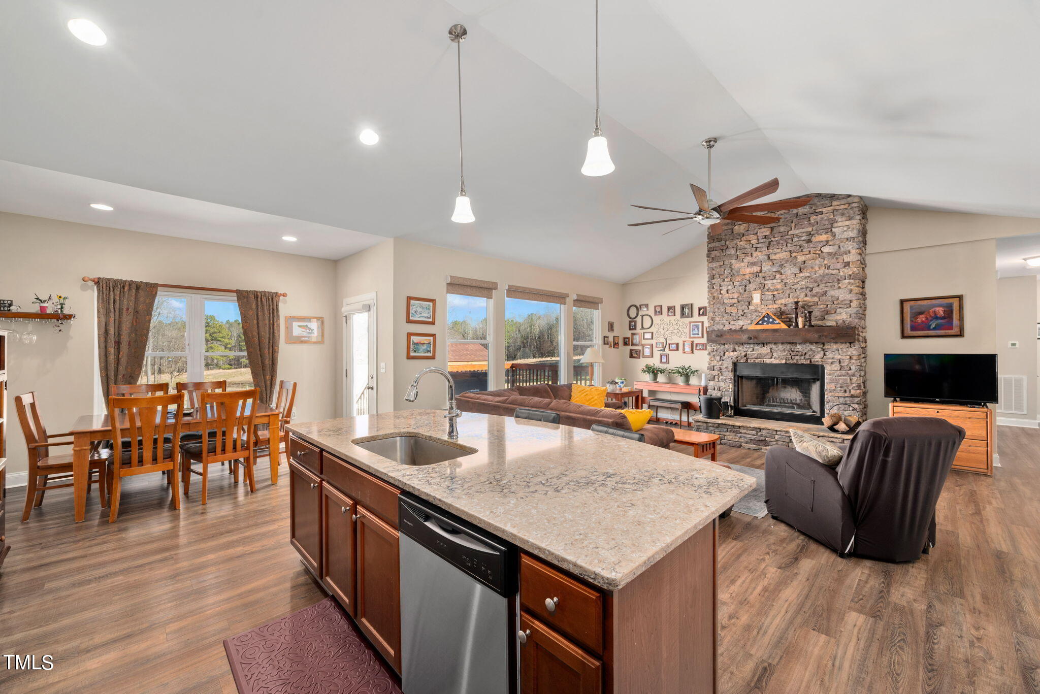 1428 Spring Valley Lake Road Henderson, NC 27537 - Photo 62 of 92 a large living room with stainless steel appliances granite countertop a stove oven a dining table and chairs with wooden floor