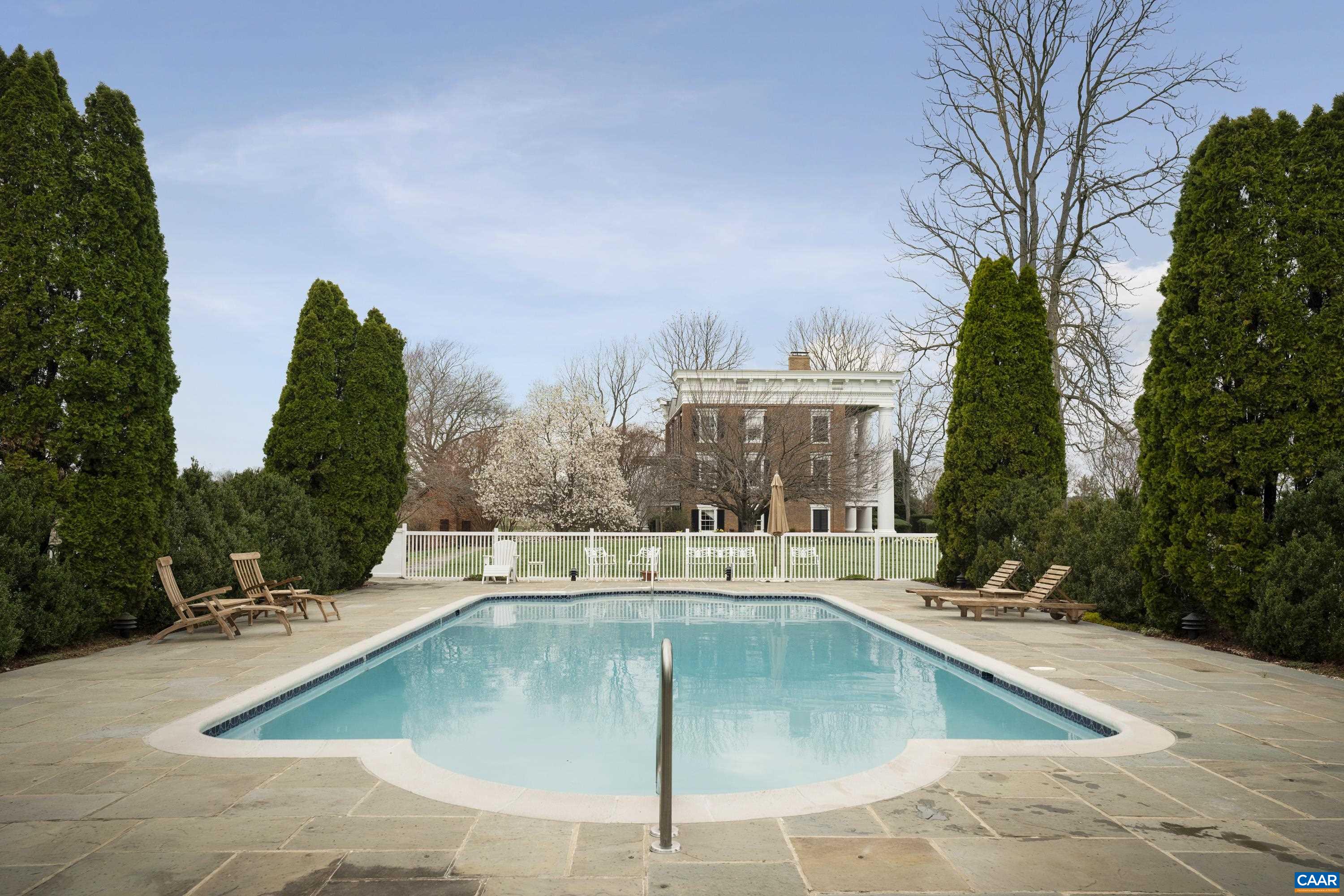23501 A Greenville Road Culpeper, VA 22701 - Photo 50 of 69 a view of a swimming pool with a bench and trees in the background