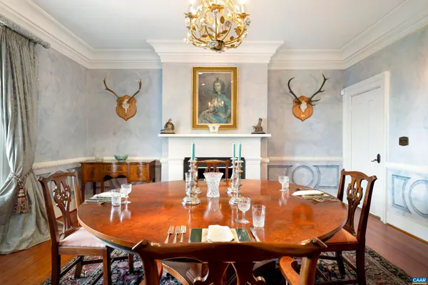 a dining room with furniture a chandelier and wooden floor