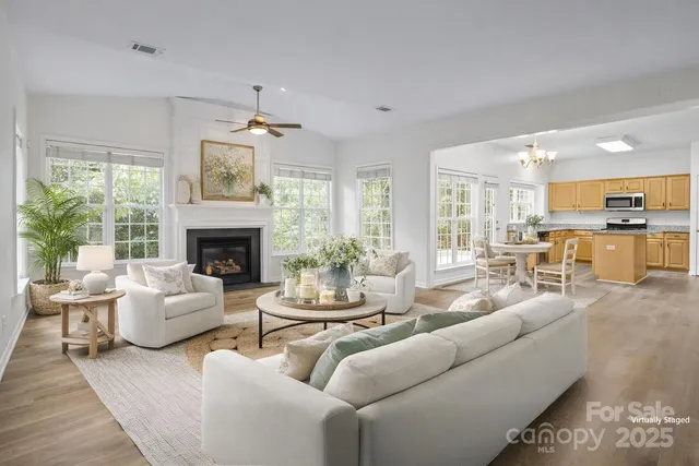 a living room with furniture fireplace and a large window
