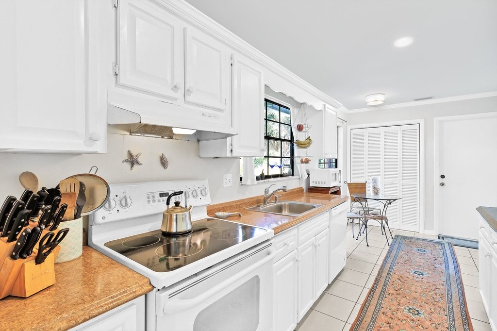 549 Layport Drive Sebastian, FL 32958 - Photo 12 of 35 a kitchen with stainless steel appliances granite countertop a sink and white cabinets