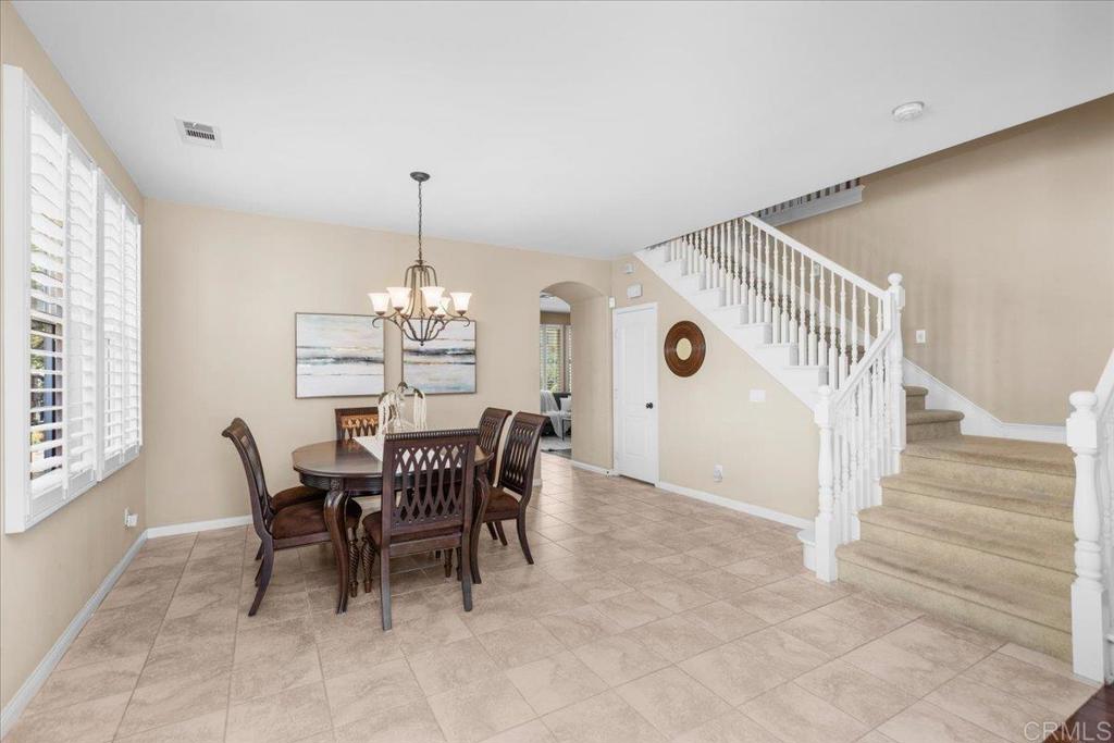 838 Luminara Way San Marcos, CA 92078 - Photo 17 of 54 a dining room with furniture a chandelier and wooden floor
