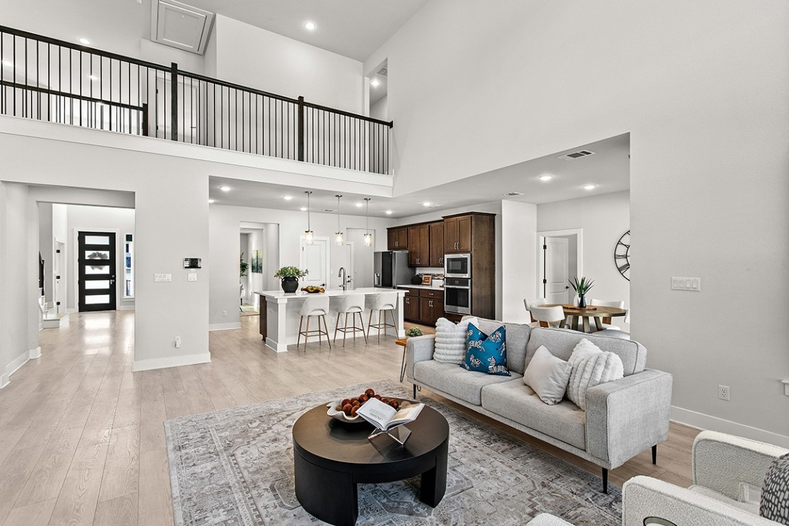 1265 Hazy Hills Loop Dripping Springs, TX 78620 - Photo 18 of 40 a living room with furniture a rug and kitchen view