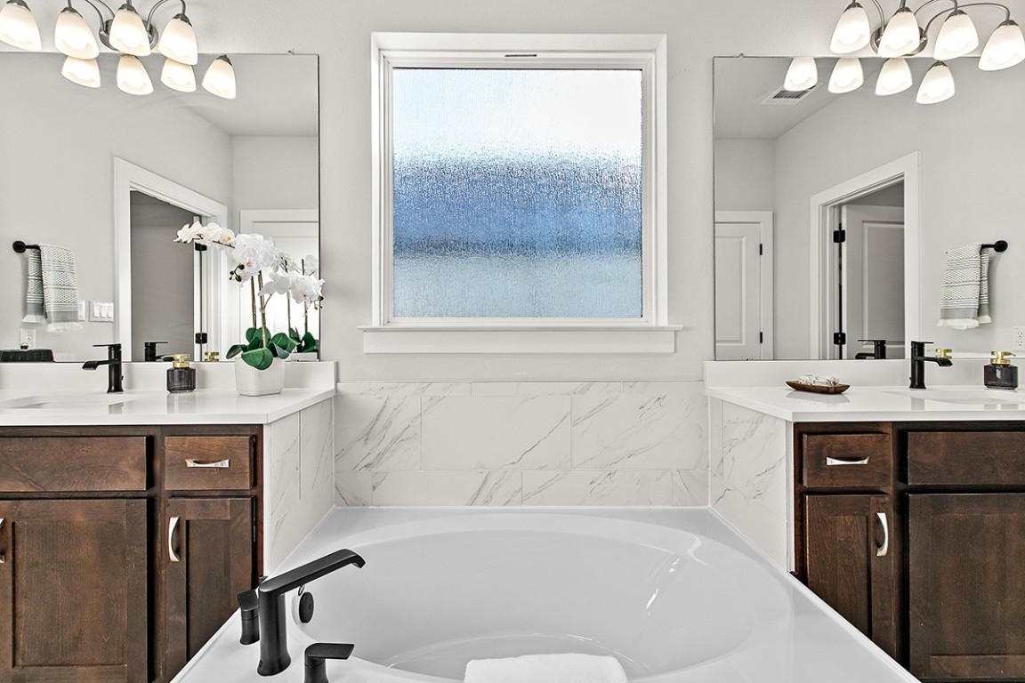 1265 Hazy Hills Loop Dripping Springs, TX 78620 - Photo 20 of 40 a bathroom with a bathtub a sink mirror and a shower