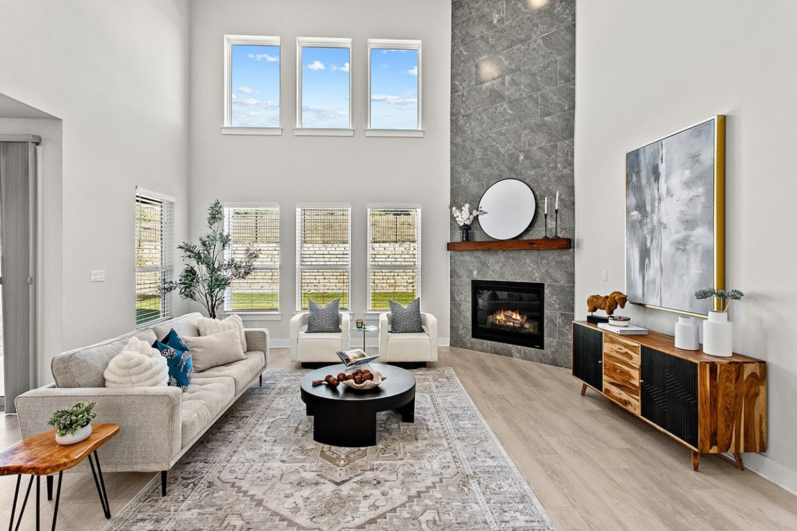 1265 Hazy Hills Loop Dripping Springs, TX 78620 - Photo 4 of 40 a living room with furniture a fireplace and a large window