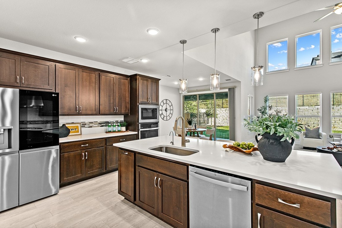 1265 Hazy Hills Loop Dripping Springs, TX 78620 - Photo 5 of 40 a kitchen with a sink stainless steel appliances and cabinets