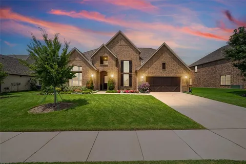 a front view of a house with a garden and yard