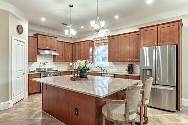 a kitchen with granite countertop a center island a sink stainless steel appliances and cabinets