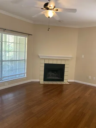 a view of empty room with wooden floor and fireplace