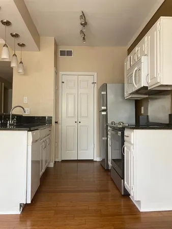 a kitchen with stainless steel appliances granite countertop a refrigerator and a stove