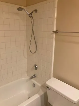 a white toilet sitting next to a bath tub and shower