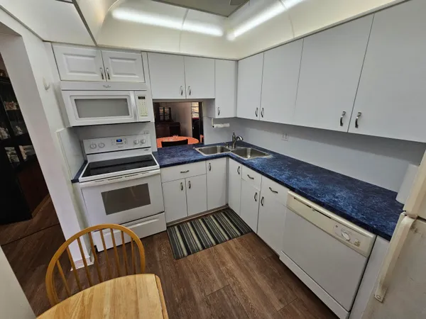 a kitchen with granite countertop a sink stainless steel appliances and cabinets