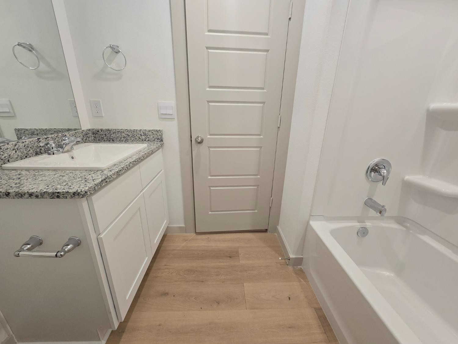 7425 8th Street Lubbock, TX 79416 - Photo 19 of 25 a bathroom with a granite countertop sink and a bathtub