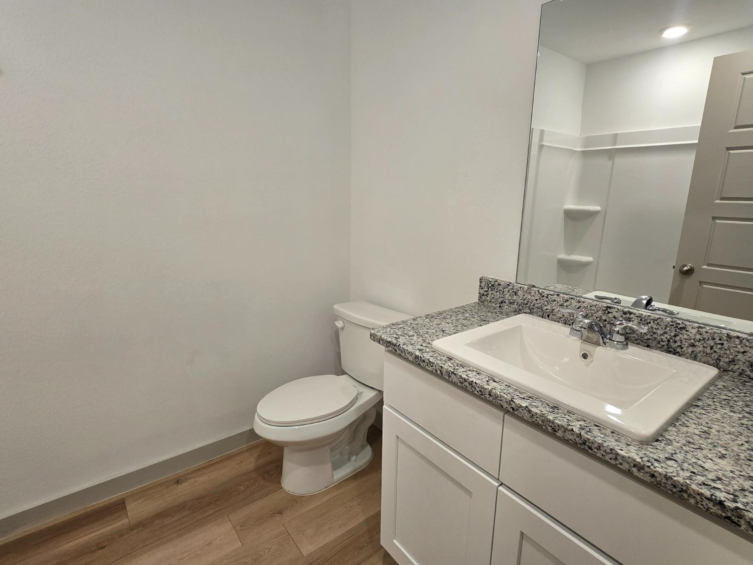 7425 8th Street Lubbock, TX 79416 - Photo 20 of 25 a bathroom with a granite countertop sink and a toilet