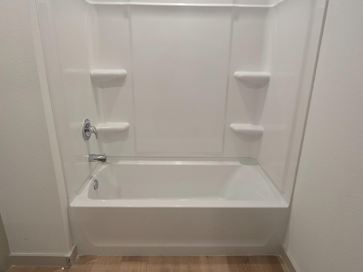 7425 8th Street Lubbock, TX 79416 - Photo 21 of 25 a white bath tub sitting next to a white toilet