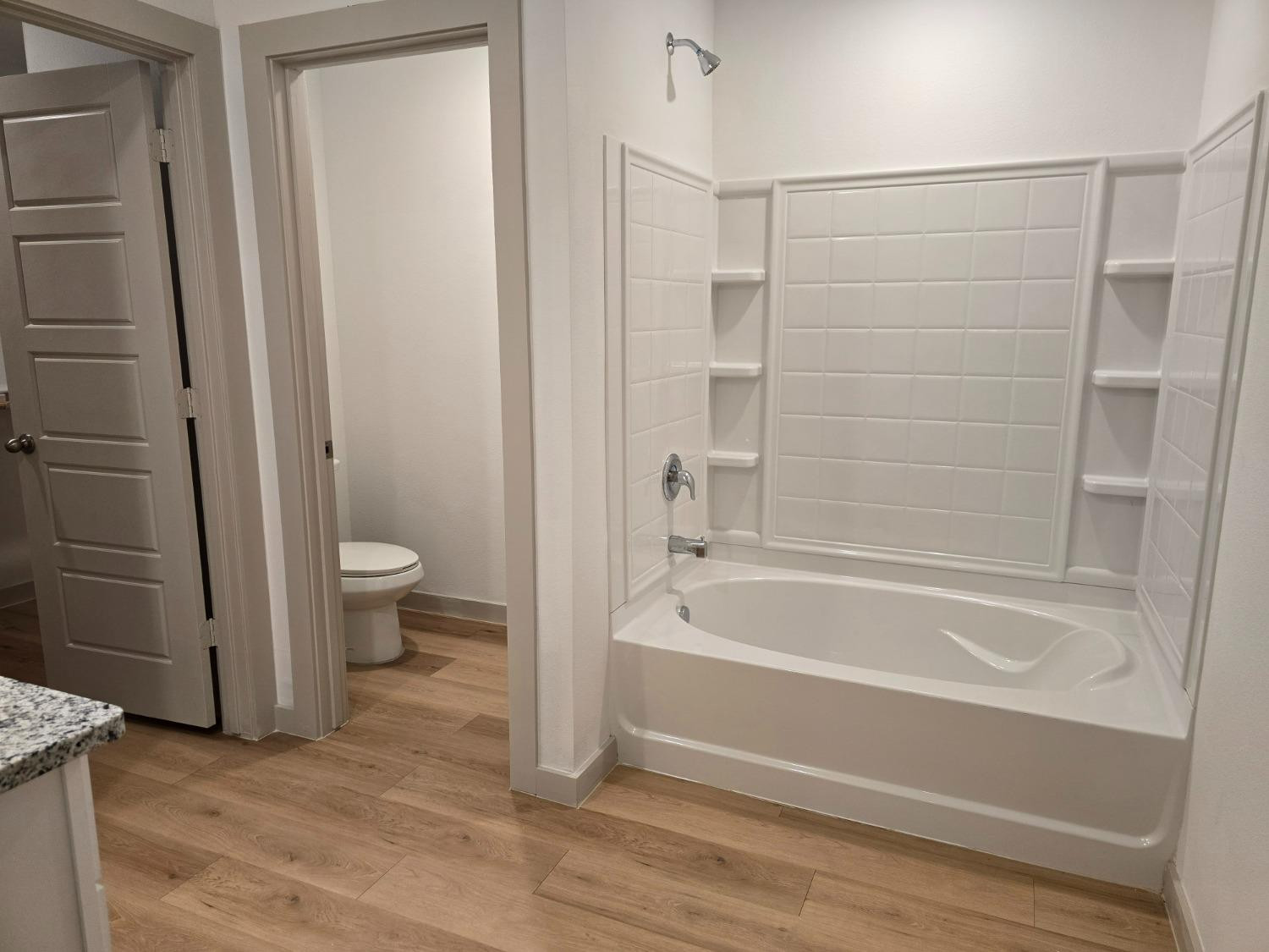 7425 8th Street Lubbock, TX 79416 - Photo 9 of 25 a bathroom with a granite countertop bathtub shower and toilet