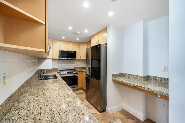 a kitchen with granite countertop stainless steel appliances and a counter top space
