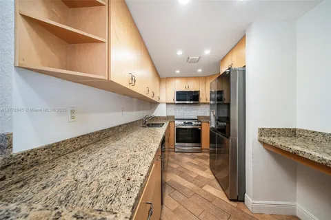 a open kitchen with stainless steel appliances granite countertop a stove a sink and a refrigerator
