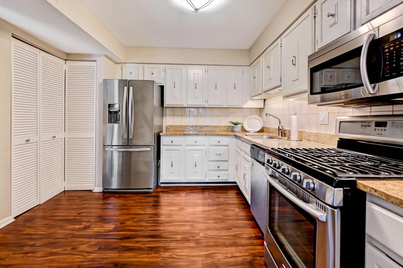 6401 Clarendon Hills Road, Unit 207 Willowbrook, IL 60527 - Photo 6 of 18 a kitchen with granite countertop a refrigerator and a stove top oven