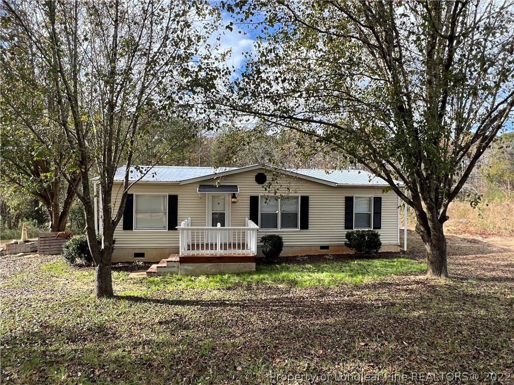 a front view of house with yard and trees