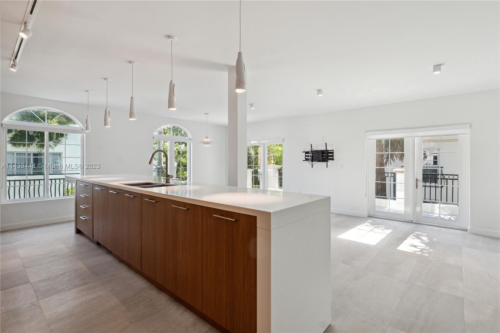 730 3rd Street, Unit 207 Miami Beach, FL 33139 - Photo 3 of 19 a large kitchen with kitchen island a large counter top a sink and stainless steel appliances