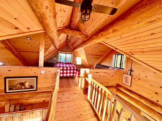 a bedroom with a bed a couch and wooden floor