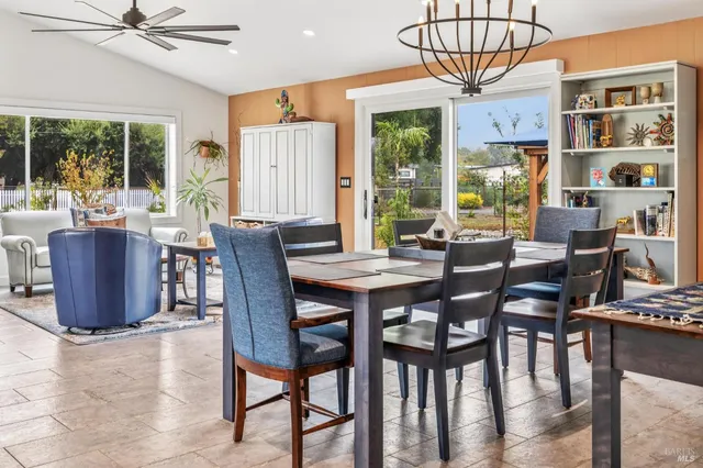 a dining room with furniture a chandelier and kitchen view