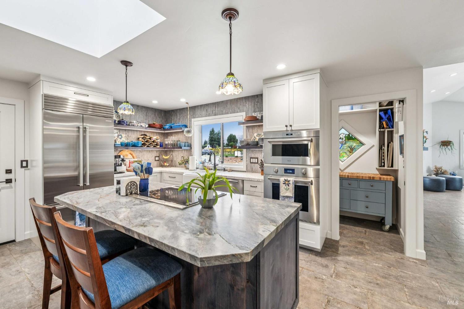 180 Adobe Canyon Road Kenwood, CA 95452 - Photo 4 of 61 a kitchen with stainless steel appliances kitchen island granite countertop a dining table chairs and refrigerator