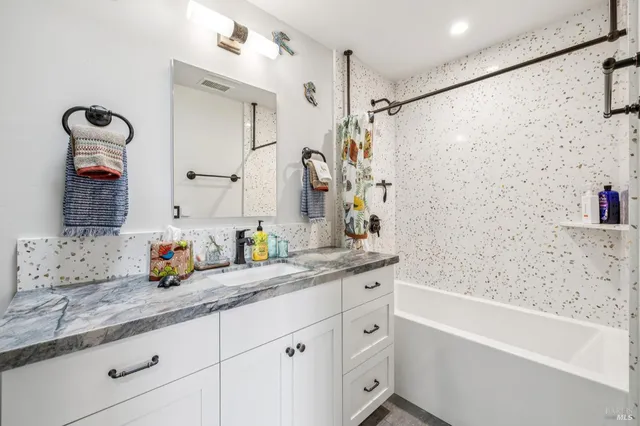 a living room with patio furniture and floor to ceiling windows