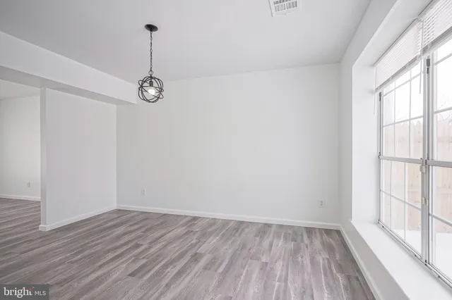 a view of a room with wooden floor and windows