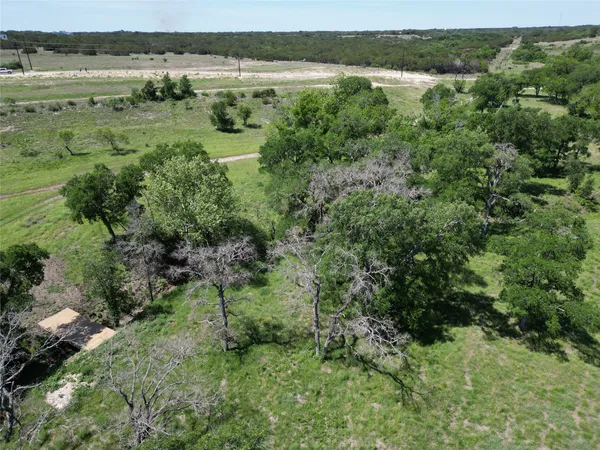 an aerial view of a houses with a yard and trees